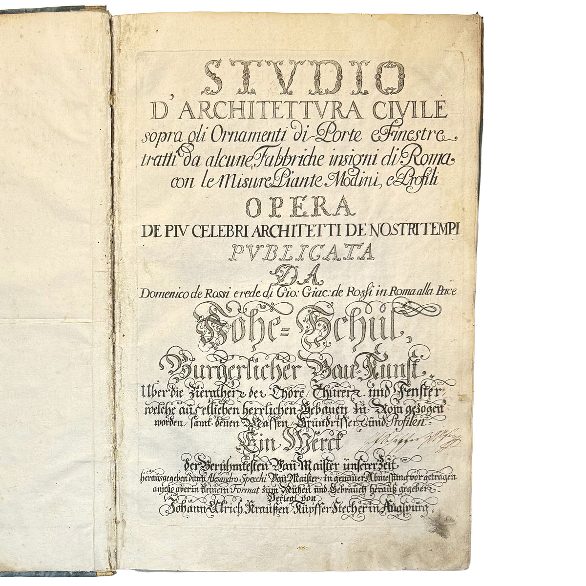 An open antique book showing a printed page in German with ornate typography and aged, yellowed paper on a plain white background.